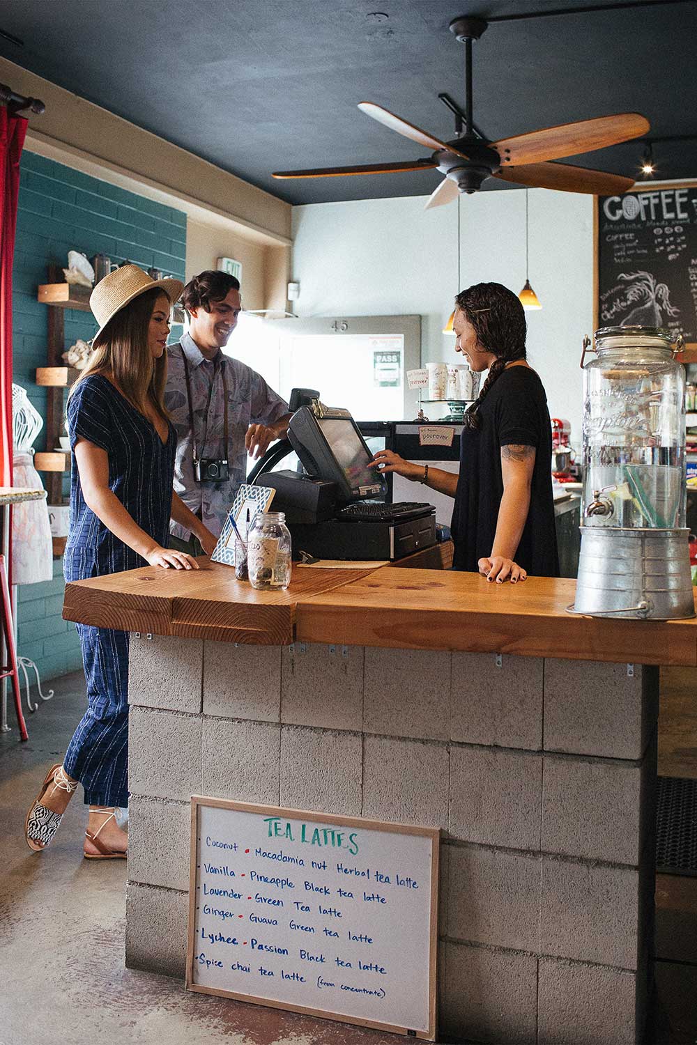 man and woman at coffee shop while cashier takes their order