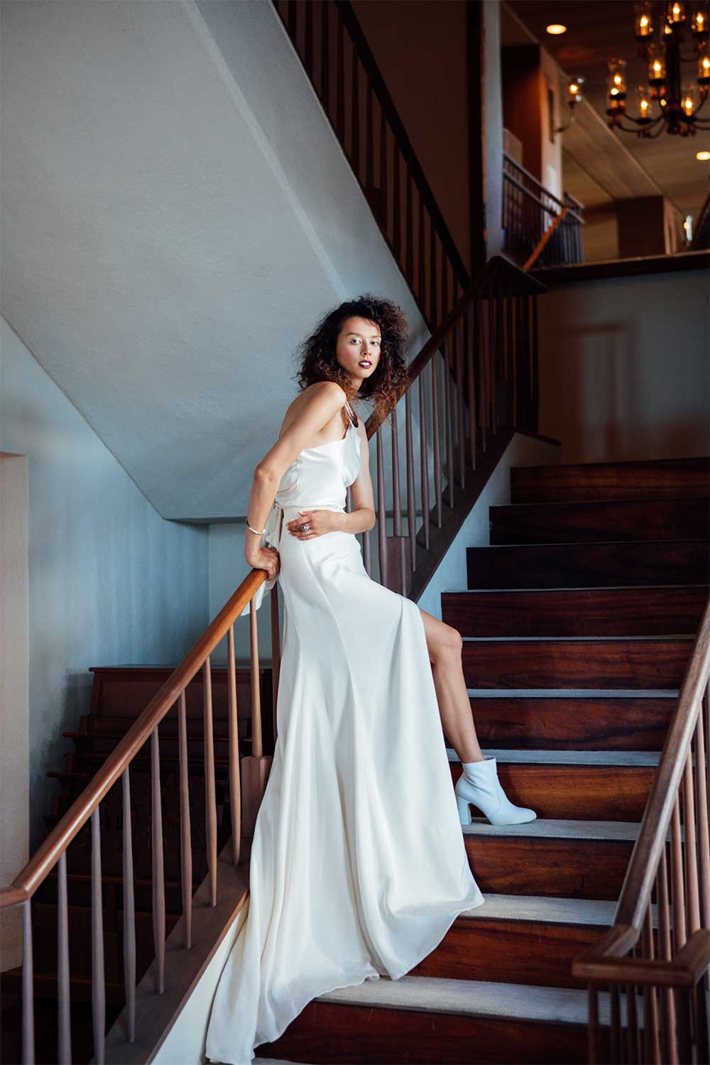 Woman in a white bridal dress standing on stairs